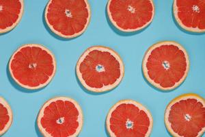 Patterns of slices of juicy Grapefruit on a blue background, a beautiful pattern. photo