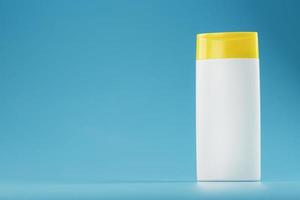 White plastic bottle with yellow cap with shampoo gel on blue background. photo
