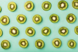 The patterns of the slices of kiwi fruit on green background as a continuous background. photo