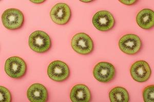 rodajas de kiwi maduras en patrones sobre un fondo rosa. foto