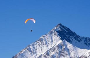 parapente sobre el pico de la montaña, deporte extremo. vuelo en paracaídas foto