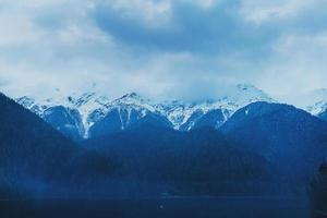 Winter lake Ritsa in Abkhazia with mountains in the snow in the background, late evening. photo