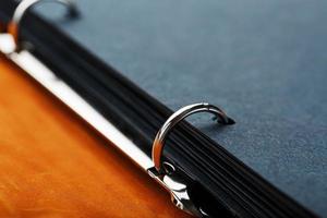 Photo album with blank black for photos. Split rings for close-up macro albums.The album cover is made of brown handmade genuine leather on a black background.