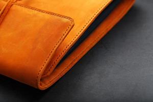 The album cover is made of brown genuine leather, handmade on a black background. Elements of a leather product close-up. photo