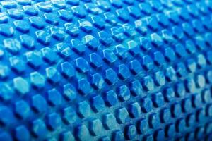 Abstract texture of a blue massage roller in the form of blue hexagonal cells. The entire screen as the background. photo