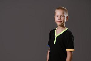 Portrait of  young guy in  black T-shirt on  gray background photo