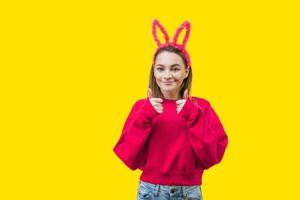 young woman in bunny ears on a yellow background photo