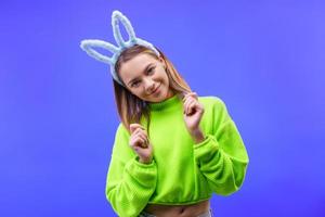 young woman in bunny ears on a blue background photo