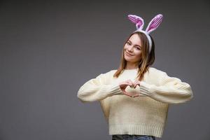 a girl in bunny ears on a gray background photo