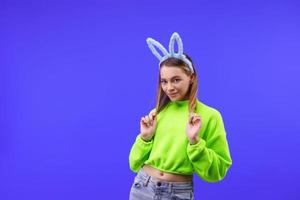 young woman in bunny ears on a blue background photo