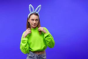 young woman in bunny ears on a blue background photo