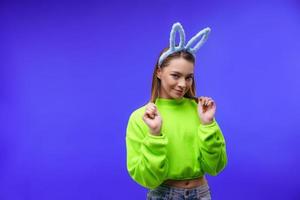 young woman in bunny ears on a blue background photo