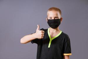 Portrait of a guy in a black mask shows a hand gesture that everything is ok photo