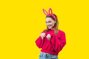 young woman in bunny ears on a yellow background photo