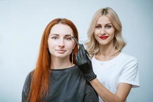 Master beautician makes markup of eyebrow tattooing, women before applying photo