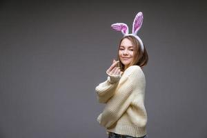 smiling young girl with bunny ears  shows a mini heart with fingers photo