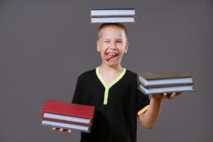 funny boy holding a book in his hands and on his head photo