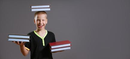 funny boy holding a book in his hands and on his head photo