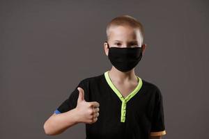 Portrait of a guy in a black mask shows a hand gesture that everything is ok photo