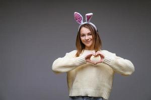 una chica con orejas de conejo en un fondo gris foto