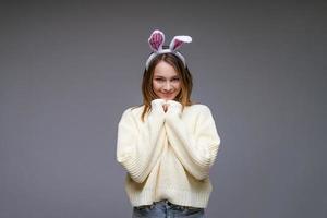 mujer joven en orejas de conejo sobre un fondo gris foto