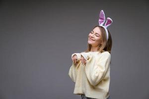 young woman in bunny ears on a gray background photo