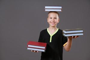 funny boy holding a book in his hands and on his head photo