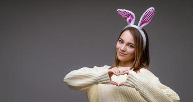 a girl in bunny ears on a gray background photo