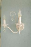 A beautiful view of the old, classic and retro style wall lamp, sconces with crystal on a grey light wall. Beautiful view and background photo