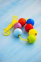 Developmental children's toy. Colored wooden balls on a rope. Colorful wooden baby beads for necklace. photo