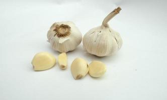 two whole garlics and some that have been peeled on a white background photo