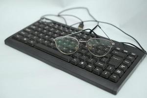 A pair of glasses on an office keyboard photo