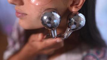 Young beautiful woman uses facial roller in skincare routine video