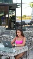 Woman in bikini sits outside using a laptop video