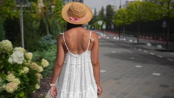 femme vêtue d'une robe blanche fluide marchant dans la rue video