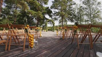 Chairs arranged for a wedding decorated with greenery and lemons video