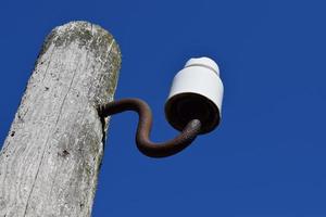 Wooden pole with an insulator photo