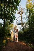 Family with kids against viewing tower at Brno, Czech Republic. Watchtower during sunset with trees. photo