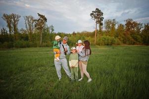 padres con tres hijos divirtiéndose juntos en el prado. foto