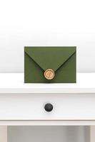 green envelope with designer cardboard and seal on a white background. Envelope with seal photo