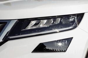 Macro view of modern white car xenon lamp headlight, bumper. Exterior of a modern car photo
