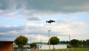 Hovering drone flying upward on a cloudy sky backdrop. copter flying . photo