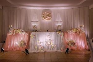 festive wedding table decoration with crystal chandeliers, golden candlesticks, candles and white pink flowers . stylish wedding day photo