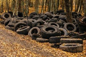 Old automobile tyre thrown out in a forest. noise is present. photo