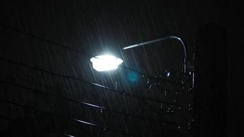 lloviendo noche y luz. gotas de lluvia cayendo en la noche en bangkok, tailandia, en la temporada de lluvias de agosto. foto