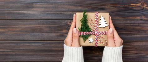 Christmas gift box wrapped in recycled paper, with ribbon bow, with ribbon on rustic banner background. Holiday concept photo
