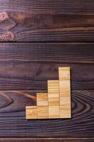 A wooden blocks cube over black wooden textured background with copy space for add word text title. Concept or conceptual Wood block stair or four steps. Cubic photo