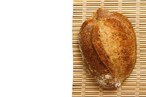 Different fresh bread on wooden plank, isolated on white background photo