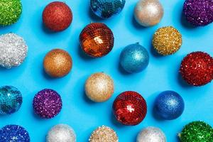 Top view of creative holiday baubles on colorful background. Christmas ornament concept photo