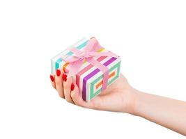 Woman hands give wrapped Christmas or other holiday handmade present in colored paper with pink ribbon. Isolated on white background, top view. thanksgiving Gift box concept photo